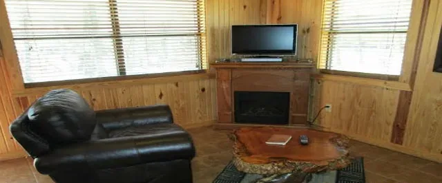 Cabin 8 living room with the corner fireplace and television