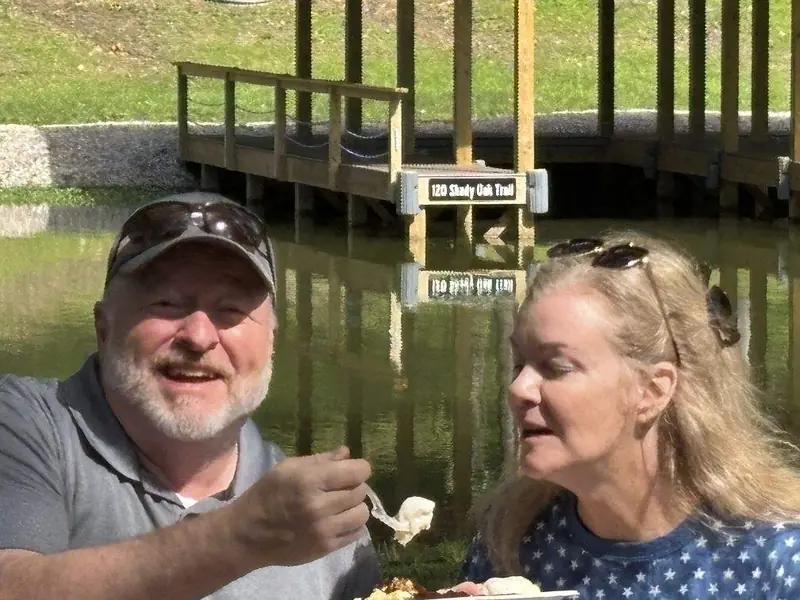 Guests eating beside the creek and the wooden footbridge