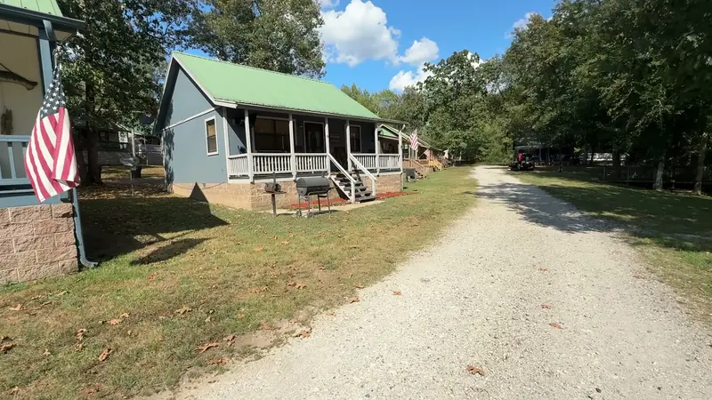 A cabin with a flag on the porch post
