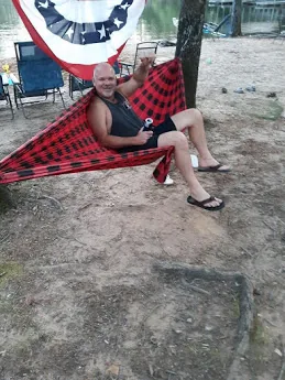 A guest sitting on the rock at the shoreline